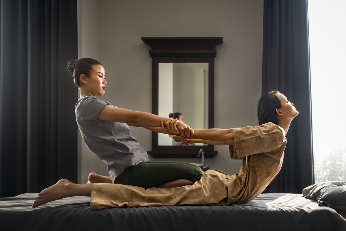 Therapist performing traditional Thai stretching during a Thai Style Signature session